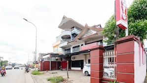 A multi-story building with a prominent sign for Hotel Sultan Hasanuddin. - Hotel O Transit 1 (Makassar)
