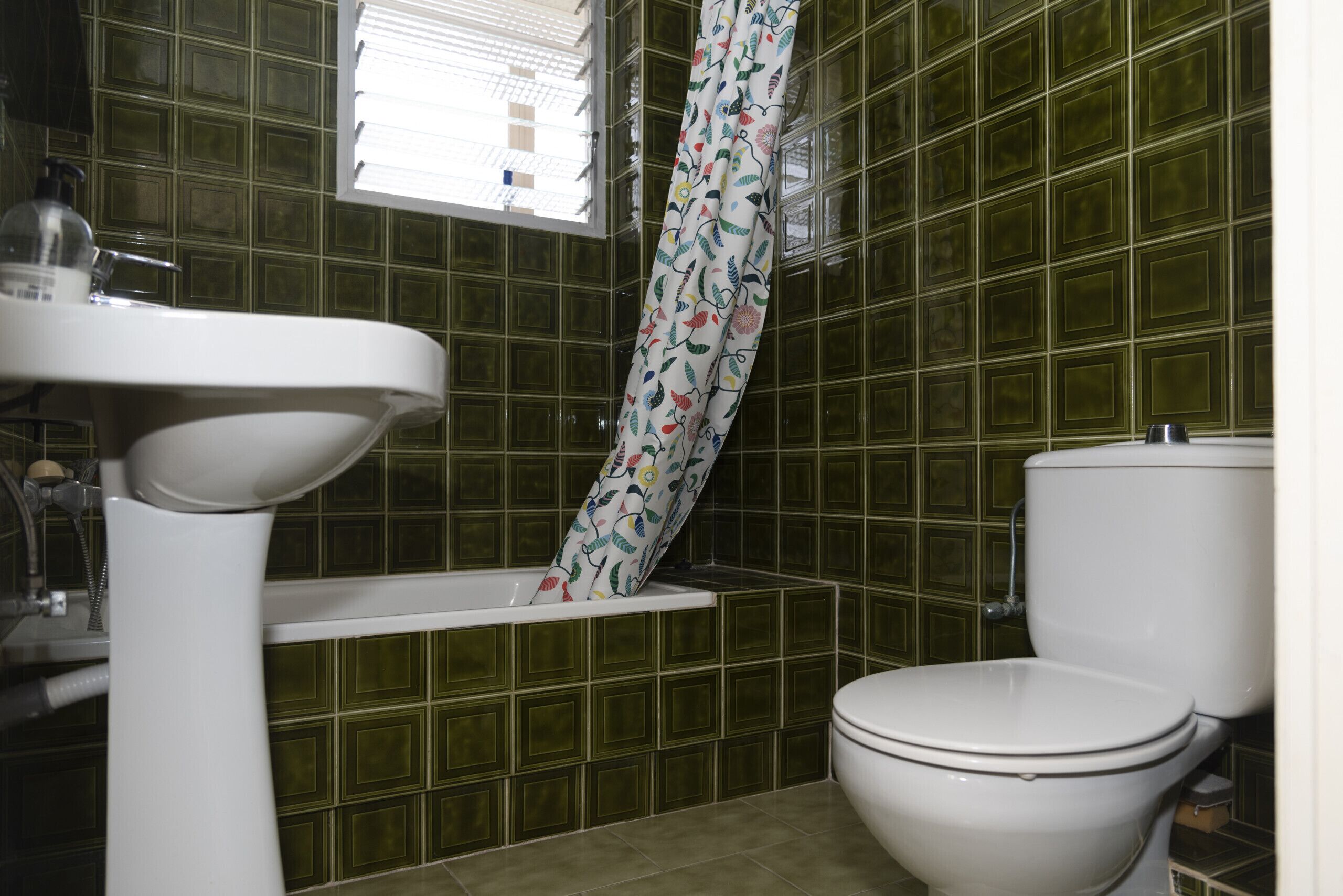 A bathroom with a white sink, a bathtub, and a toilet.