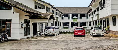 A multi-story building with a central courtyard, featuring a mix of modern and traditional architectural elements, including a tiled roof and a large open space in the middle.