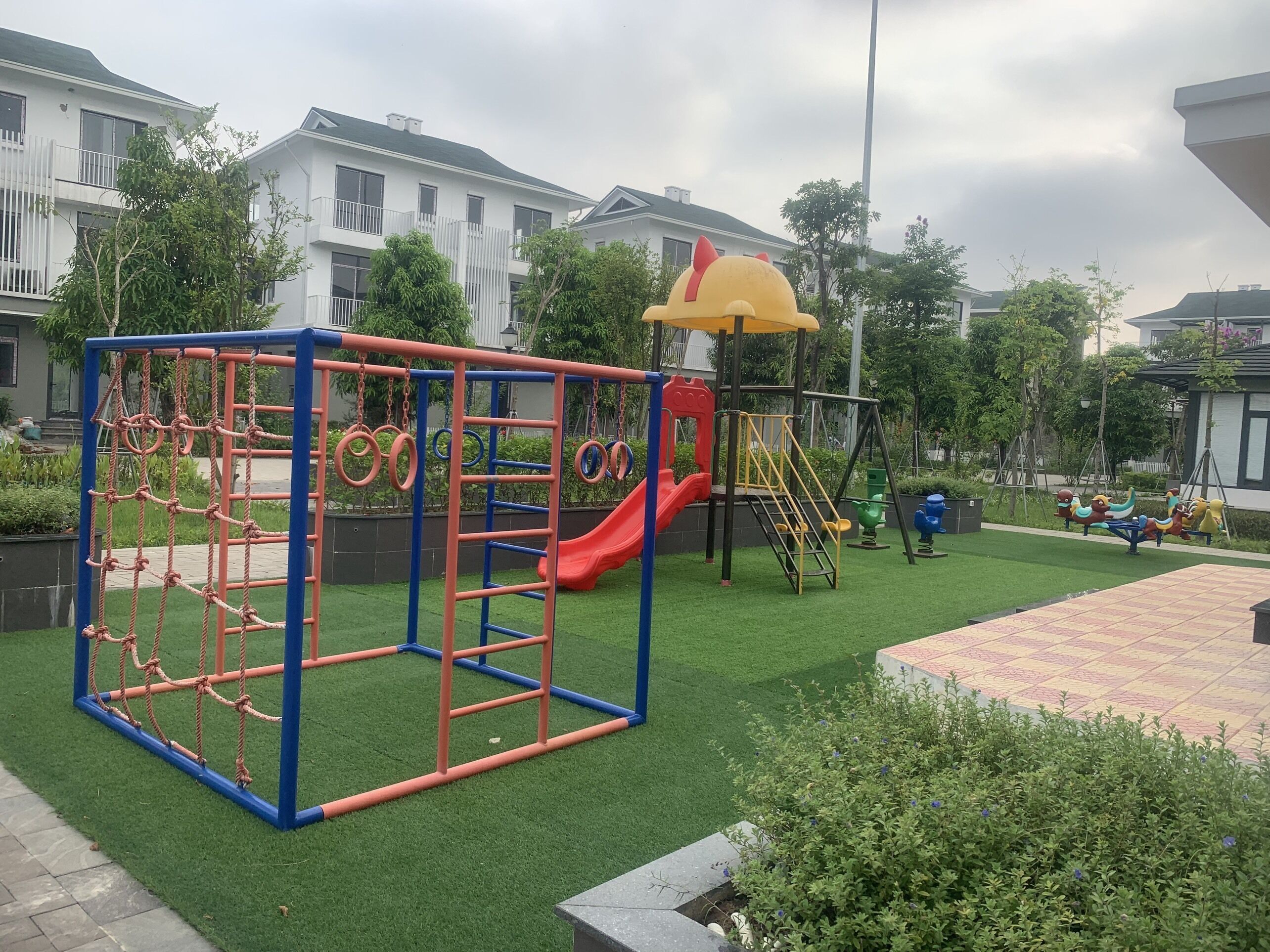 A playground with a rope net, slide, and climbing structures.