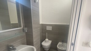 A modern bathroom with a sink, bidet, and toilet. - B&B HOTEL LUCCIOLA (Cattolica)