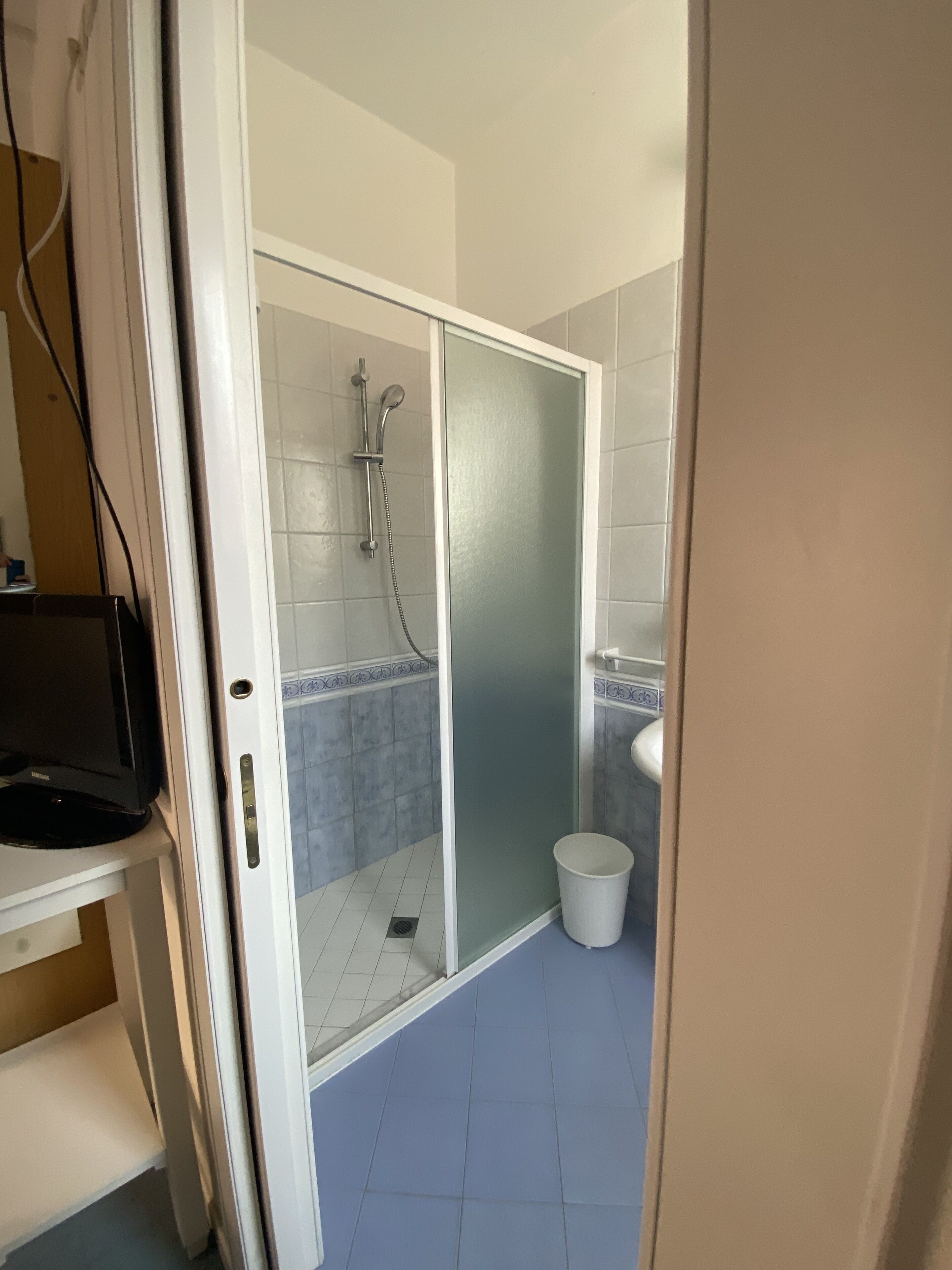 A bathroom with a shower, toilet, and sink.