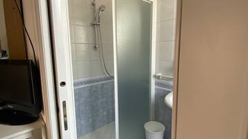 A bathroom with a shower, toilet, and sink.