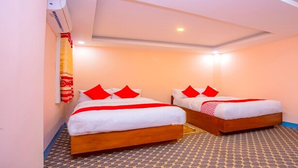 A hotel room with two single beds, each with red and white bedding, and a patterned floor. - MeroStay 113 Hotel TMT (Kathmandu)