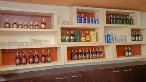 A bar with multiple shelves displaying various bottles and glasses. - MeroStay 113 Hotel TMT (Kathmandu)