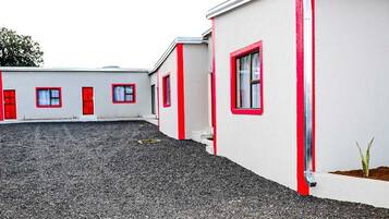 Ein Gebäude mit mehreren Räumen, jedes mit roter Tür und Fensterrahmen.