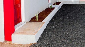 A building with a red door, a small window, and a white wall. - Shakwaneng Lodge (Greater Tubatse)