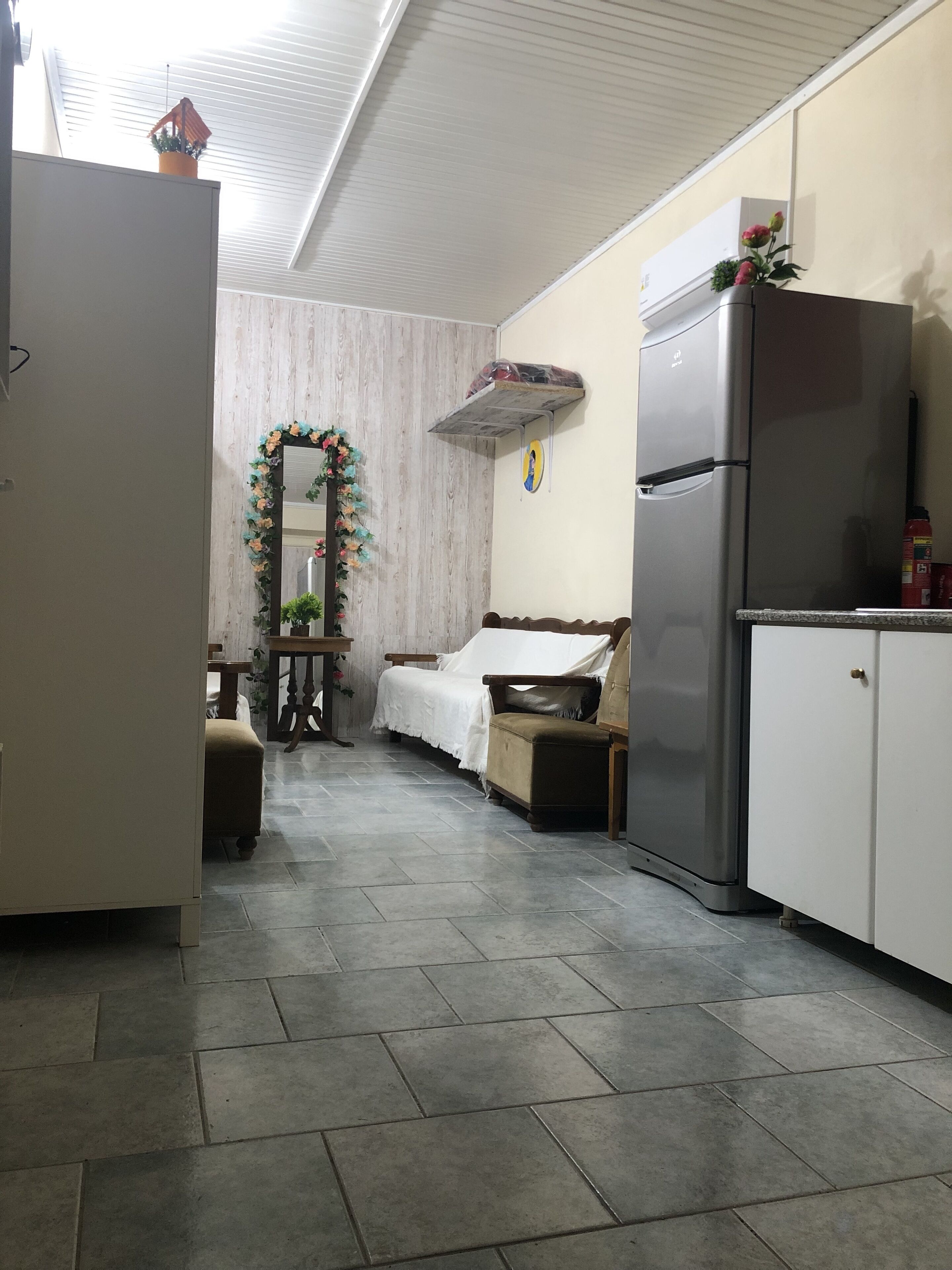 A compact kitchen with a refrigerator, a sink, and a dining area with a table and chairs.