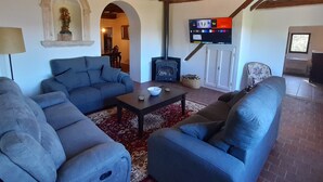 A living room with a fireplace, sofas, and a television.