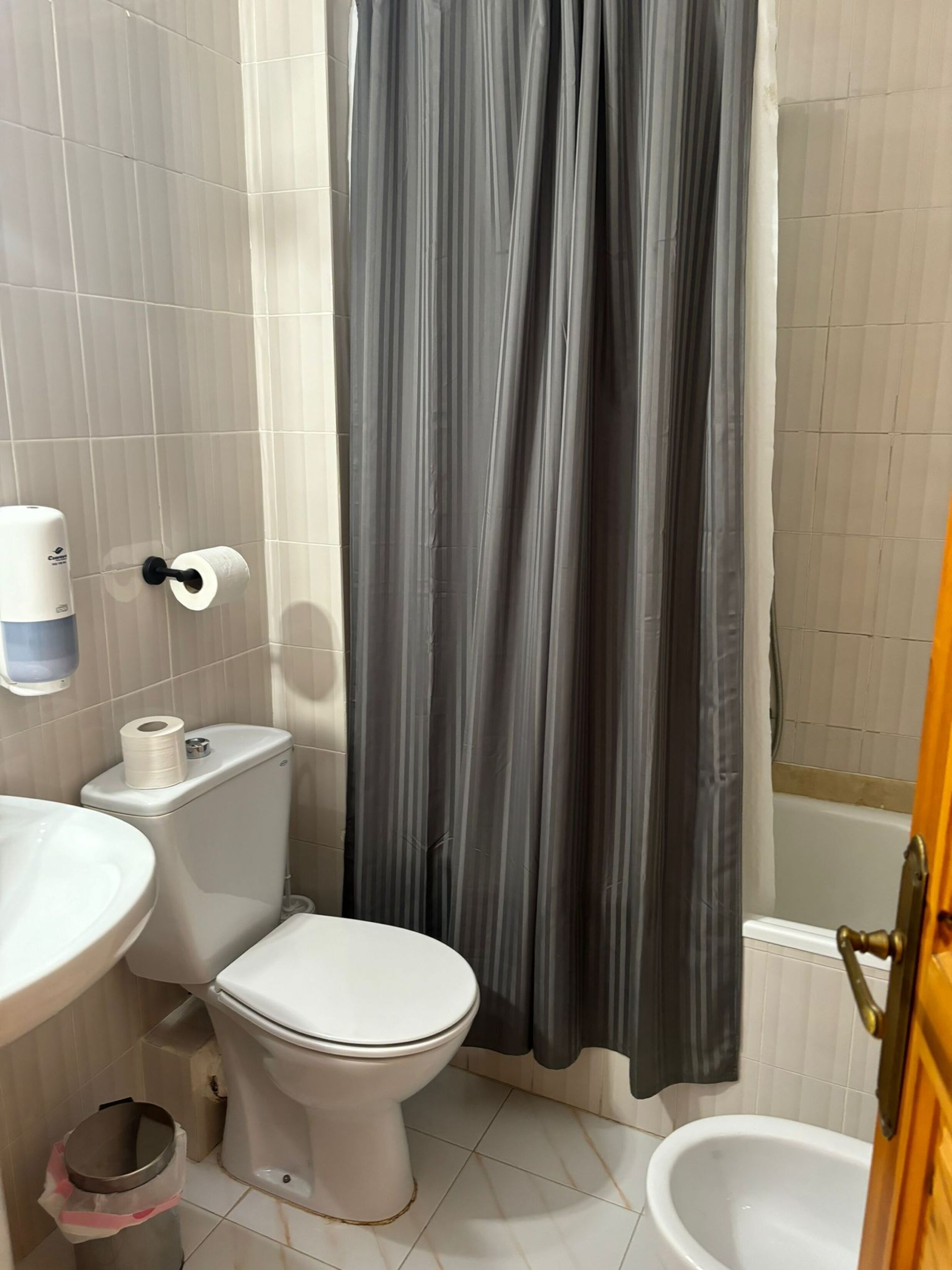 Un baño con inodoro, lavamanos y bañera.