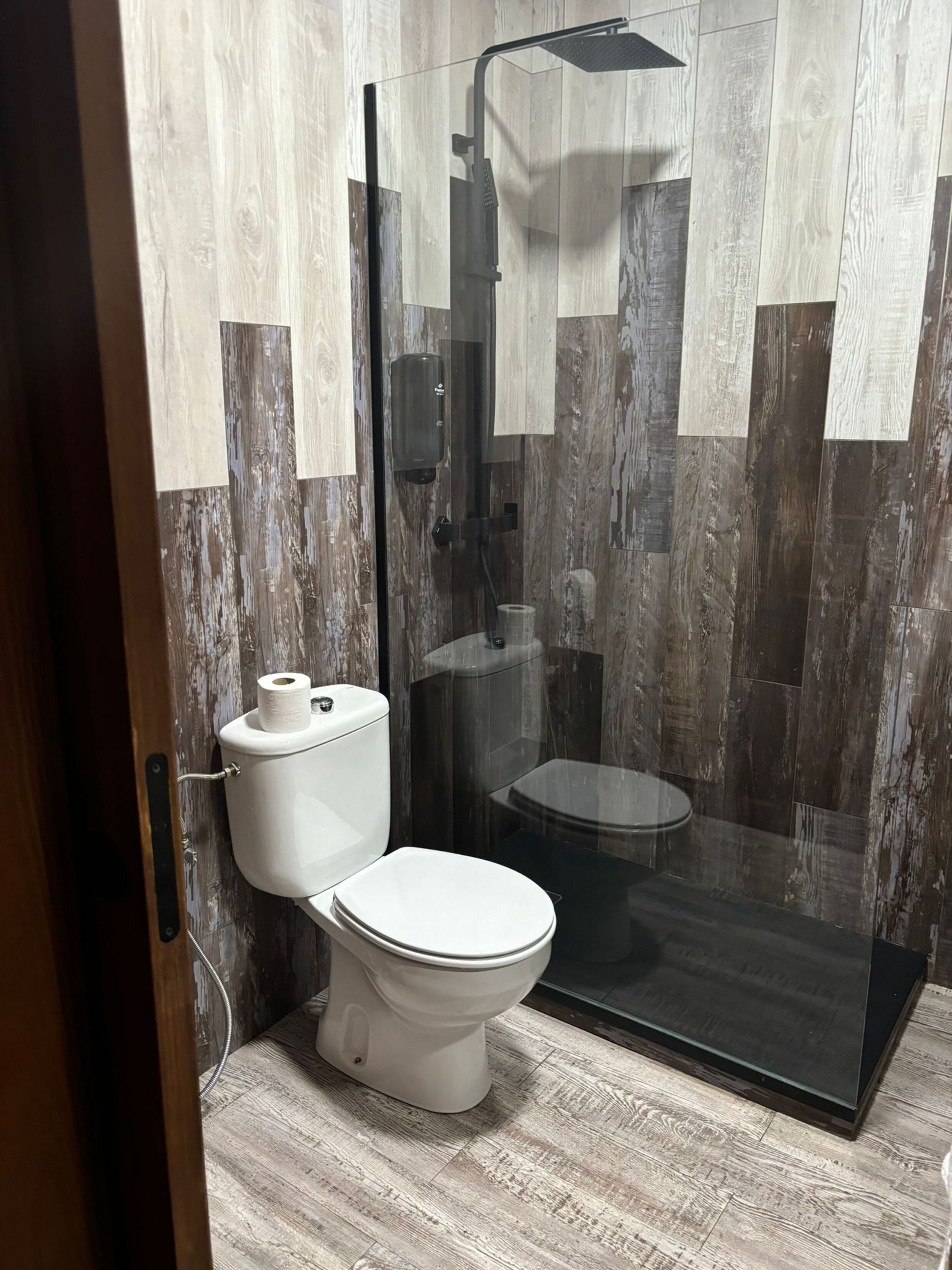 Un baño moderno con cabina de ducha de vidrio, inodoro y bidé.