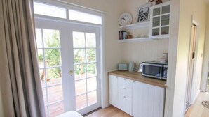 A small kitchen with a microwave, toaster, and shelves above the counter.