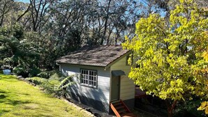 A small, single-story house with a sloped roof, a front door, and a small porch with steps.