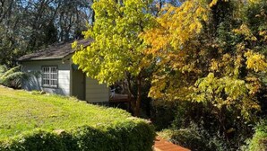 A residential property with a wooden deck, a well-maintained lawn, and a house with a visible window.