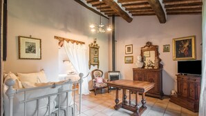 Une pièce comprenant un lit, une table en bois, une chaise, une cheminée et un téléviseur.