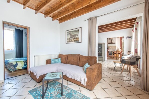 Ein gemütliches Wohnzimmer mit einem braunen Sofa, einem kleinen Tisch und einem Teppich.