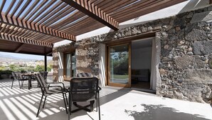 An outdoor patio with stone walls, a pergola, and a view of the landscape. - Country House 'Iris - Finca La Suerte Grande' with Mountain Views and Wi-Fi (Telde)