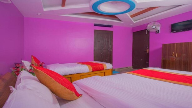 A room with two beds, a wooden wardrobe, and a ceiling fan. - MeroStay 117 Siddhi Binayak Hotel (Tohka)
