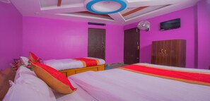 A room with two beds, a wooden wardrobe, and a ceiling fan. - MeroStay 117 Siddhi Binayak Hotel (Tohka)