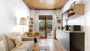 Ein modernes Wohnzimmer mit einer Couch, einem Couchtisch und einem Essbereich mit Stühlen.