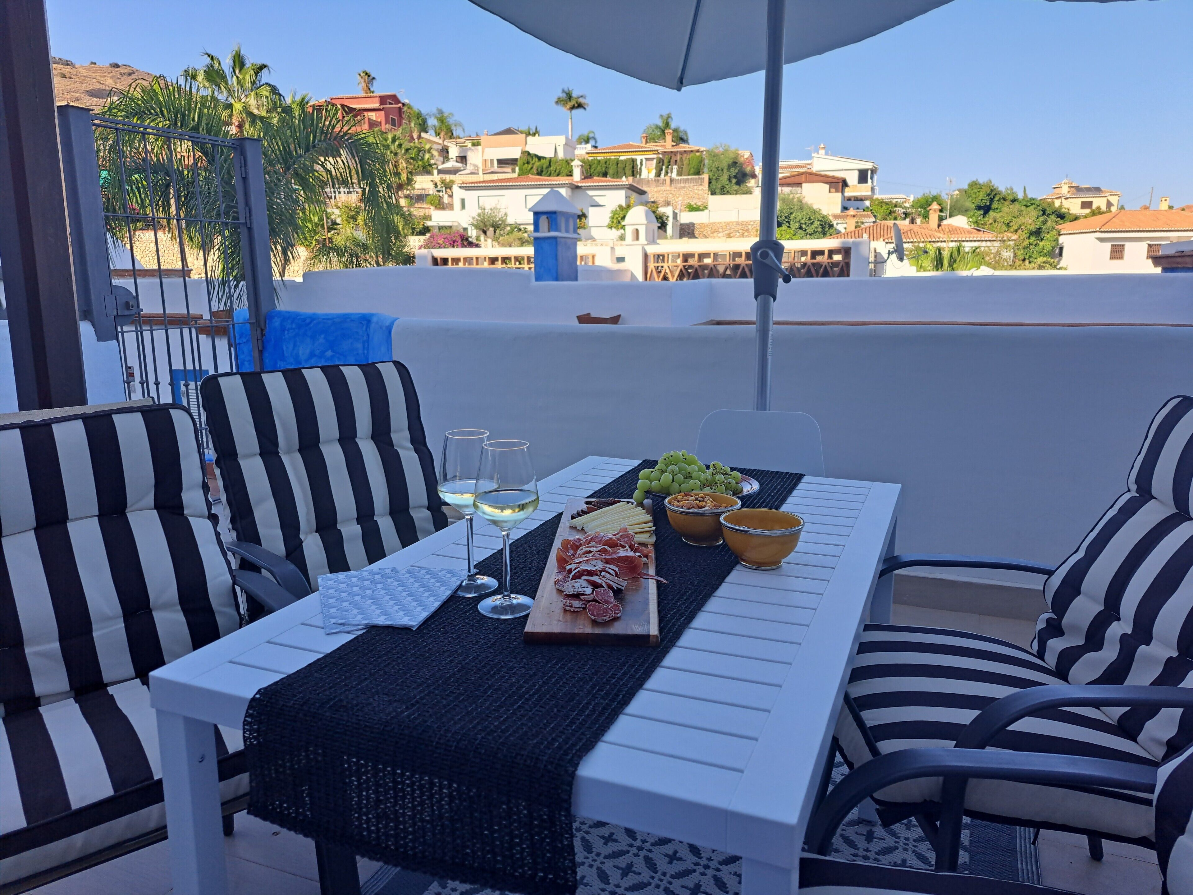 Terraza en la azotea con una mesa dispuesta para dos personas, con vistas a la ciudad.