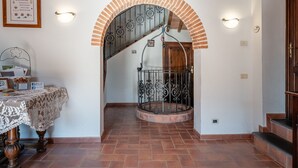 A staircase with a wrought iron railing, a wooden door, and a wall-mounted light fixture. - Holiday Apartment "Le Rondini" with Shared Pool, Shared Garden & Wi-Fi (Lamporecchio)