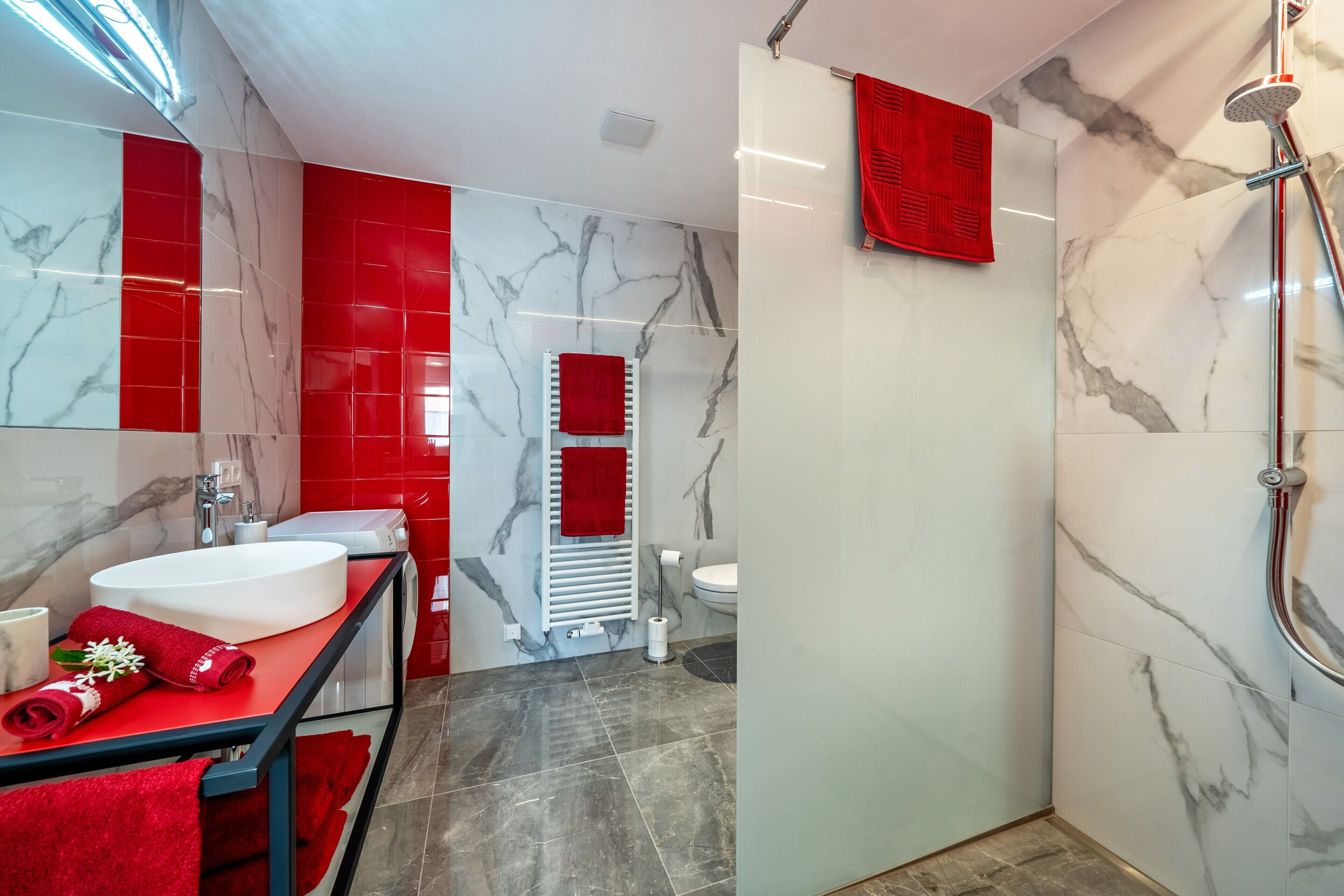 Ein modernes Badezimmer mit zwei Waschbecken, einer Dusche und einer Toilette.