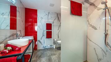Ein modernes Badezimmer mit zwei Waschbecken, einer Dusche und einer Toilette.