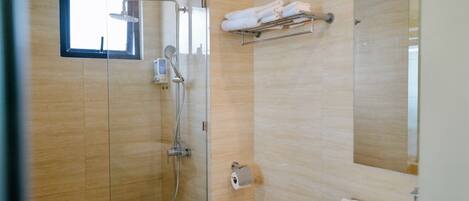 A modern bathroom with a glass-enclosed shower, a toilet, a sink, and a towel rack.