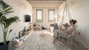 Un salon moderne avec un fauteuil suspendu, un téléviseur à écran plat et une grande plante.