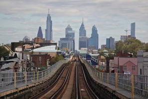 A train station with tracks leading towards a city skyline.