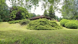 Un edificio japonés tradicional rodeado de exuberante vegetación y arbustos bien cuidados.