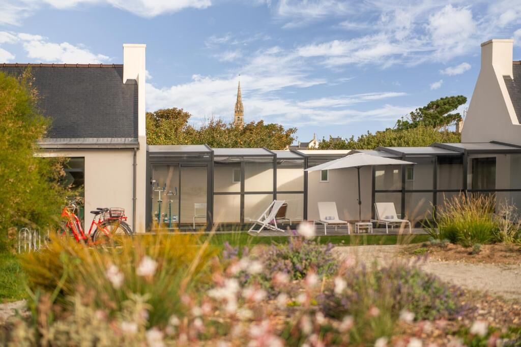 A modern building with a glass facade, outdoor seating area, and a bicycle parked outside.