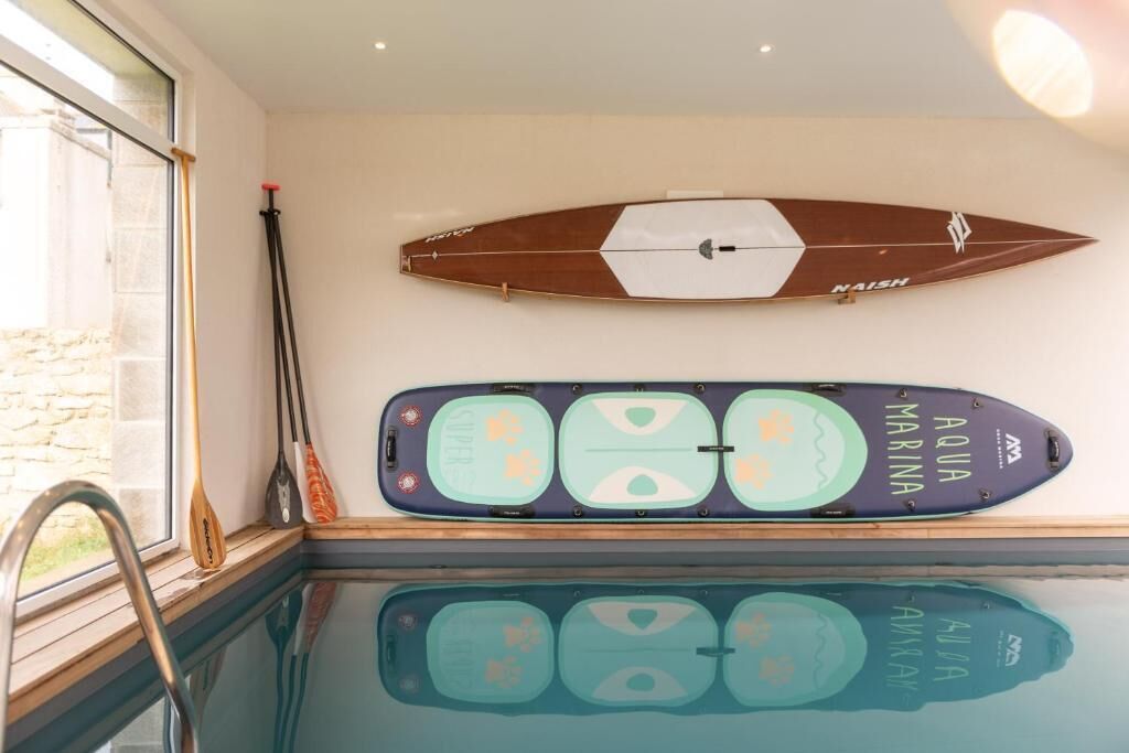 A swimming pool with two surfboards mounted on the wall.