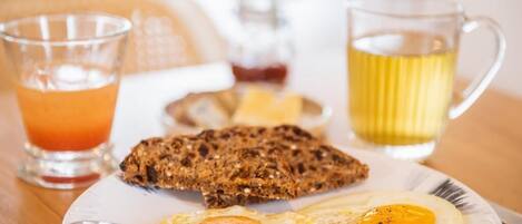 A breakfast plate with eggs, toast, and a glass of orange juice.