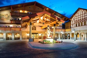 Un hotel con un cortile centrale, una grande statua e uno stile architettonico europeo tradizionale.