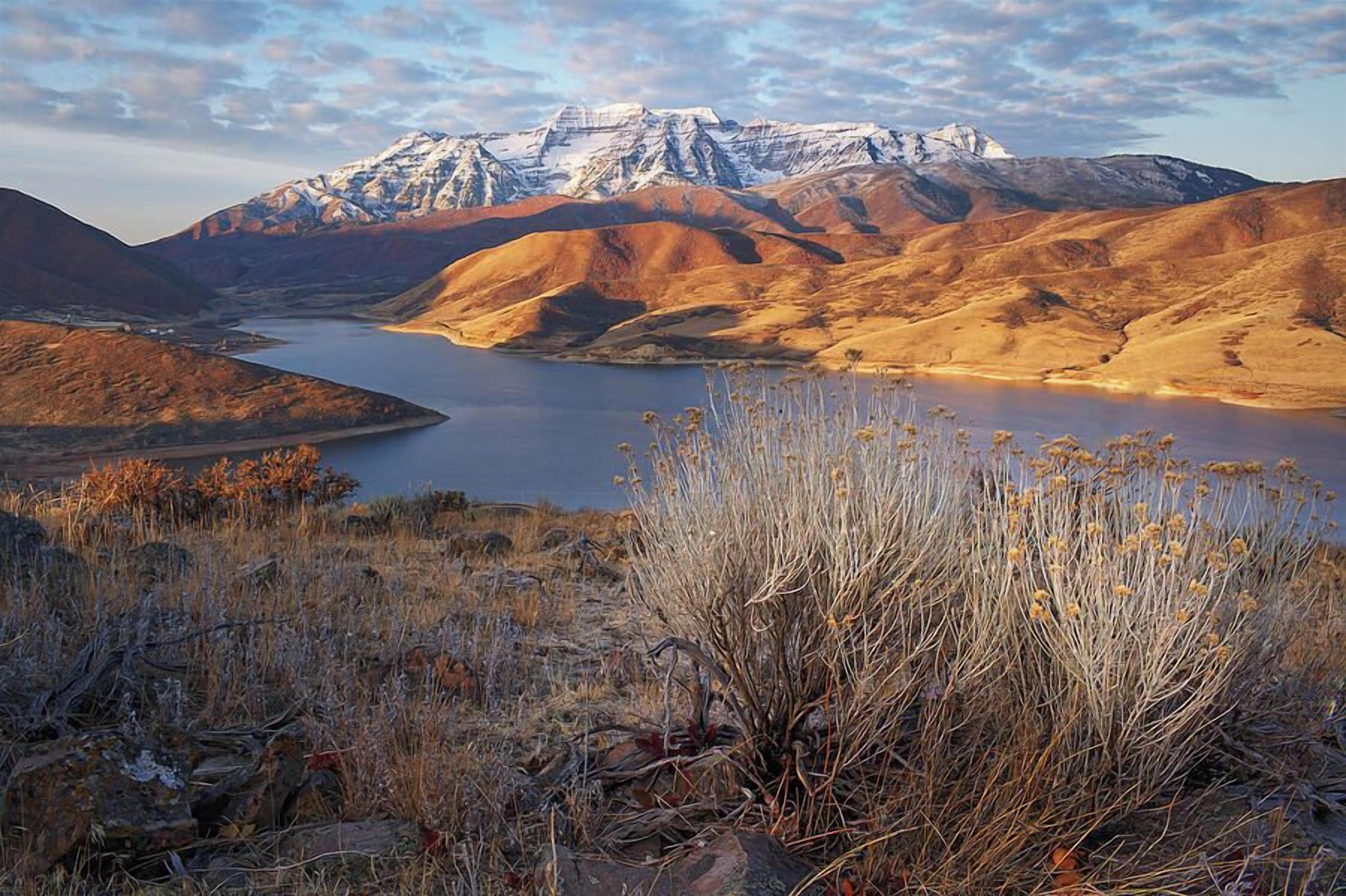 A mountainous landscape with a lake and dry vegetation.