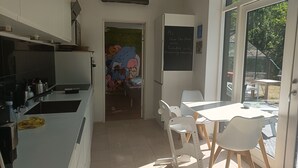 A kitchen with white cabinets, a blackboard, and a mural on the wall. - 3 bedroom private vacation home in silkeborg (Silkeborg)