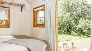 Une chambre à coucher avec un lit, une fenêtre et une vue sur un jardin extérieur.
