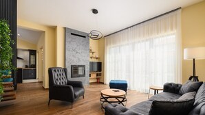 A modern living room with a fireplace, a sofa, a round coffee table, and a dining area in the background. - Luxury Villa Istra Maruzini with private pool in Rovinj,  Istria (Maružini)