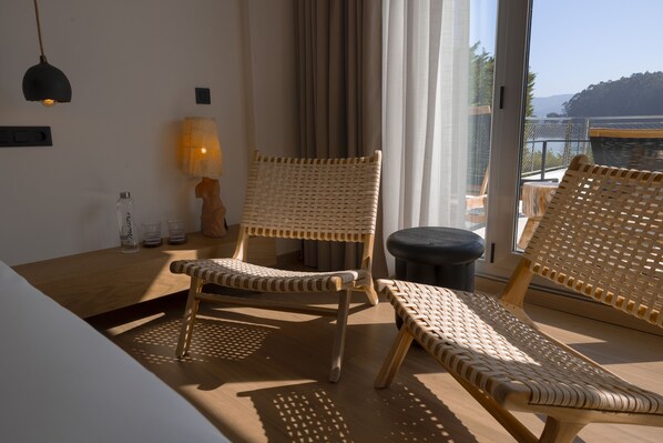Una habitación con muebles de mimbre, una lámpara y vista al mar.