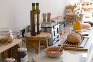 Monipuolinen aamiaisbuffet, jossa on tarjolla erilaisia ruokia, kuten leipää, juustoa ja lisukkeita.