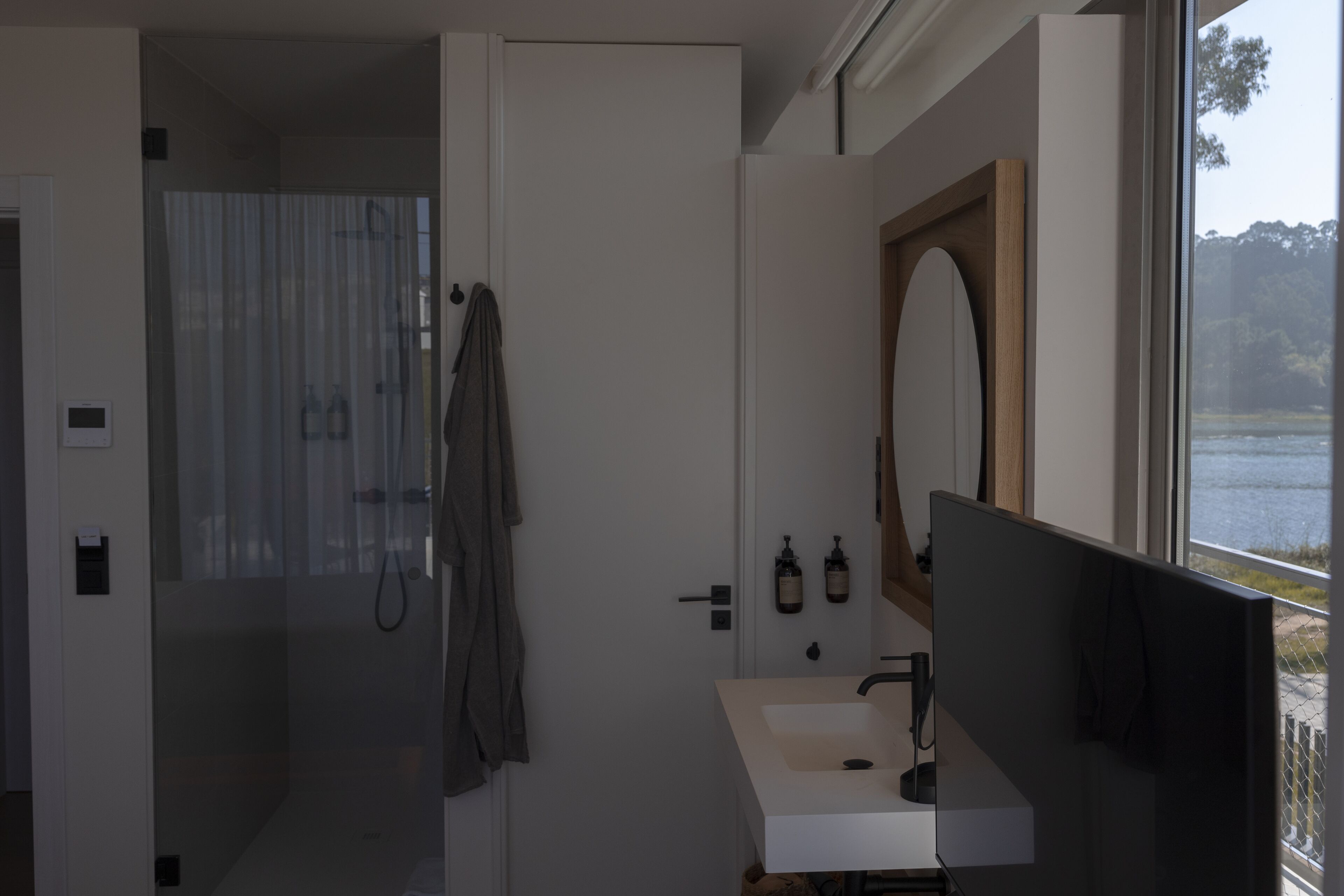 A modern bathroom with a shower, a sink, and a large mirror.