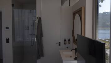 A modern bathroom with a shower, a sink, and a large mirror.