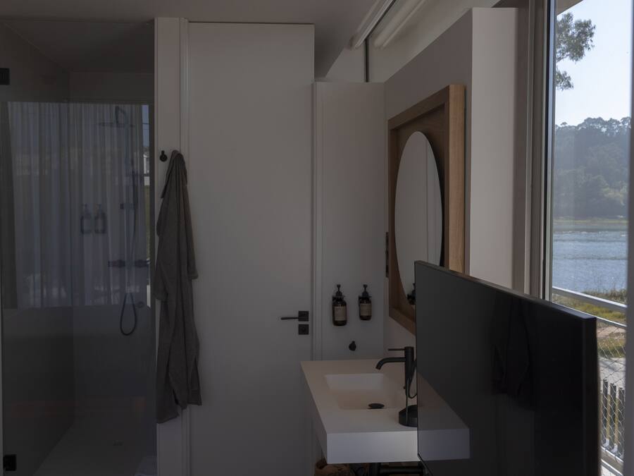 Ein modernes Badezimmer mit Dusche, Waschbecken und einem großen Spiegel.