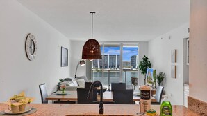 Una cocina moderna con un lavabo doble, un comedor con vistas a la ciudad y un ventanal grande.