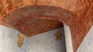 A room with a brick archway, a textured wall, and a metal rod. - La Torre - Deluxe Apartment 1 (Santo Stefano di Camastra)