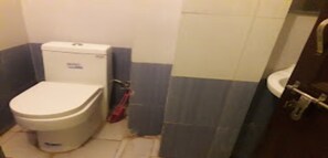 Une salle de bain comprenant des toilettes, un lavabo et un espace douche.