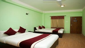 Une chambre d’hôtel avec deux lits, un ventilateur de plafond, une télévision et une porte avec une pancarte.