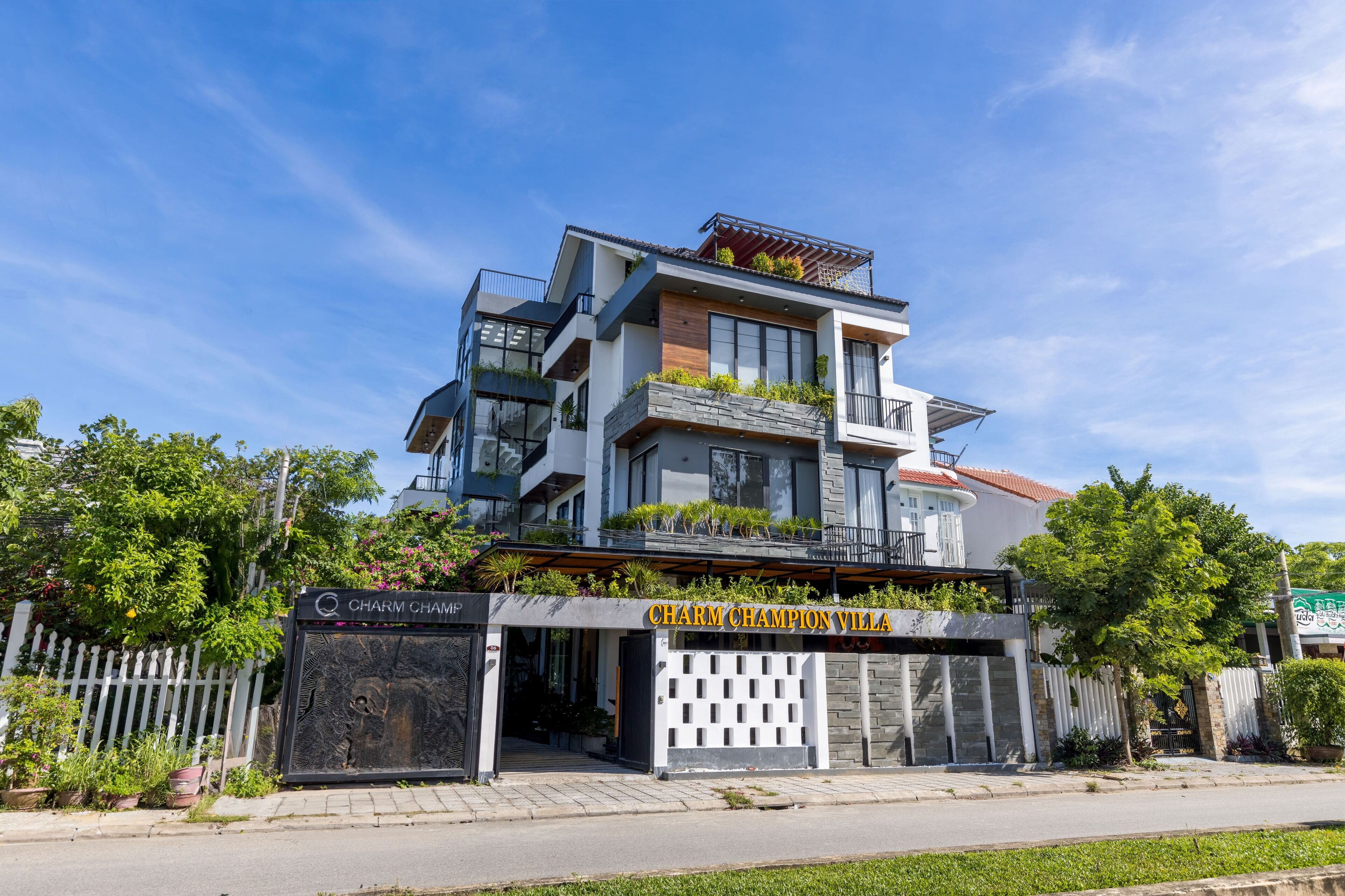 A modern multi-story building with a sign reading "Charm Champion Villa."